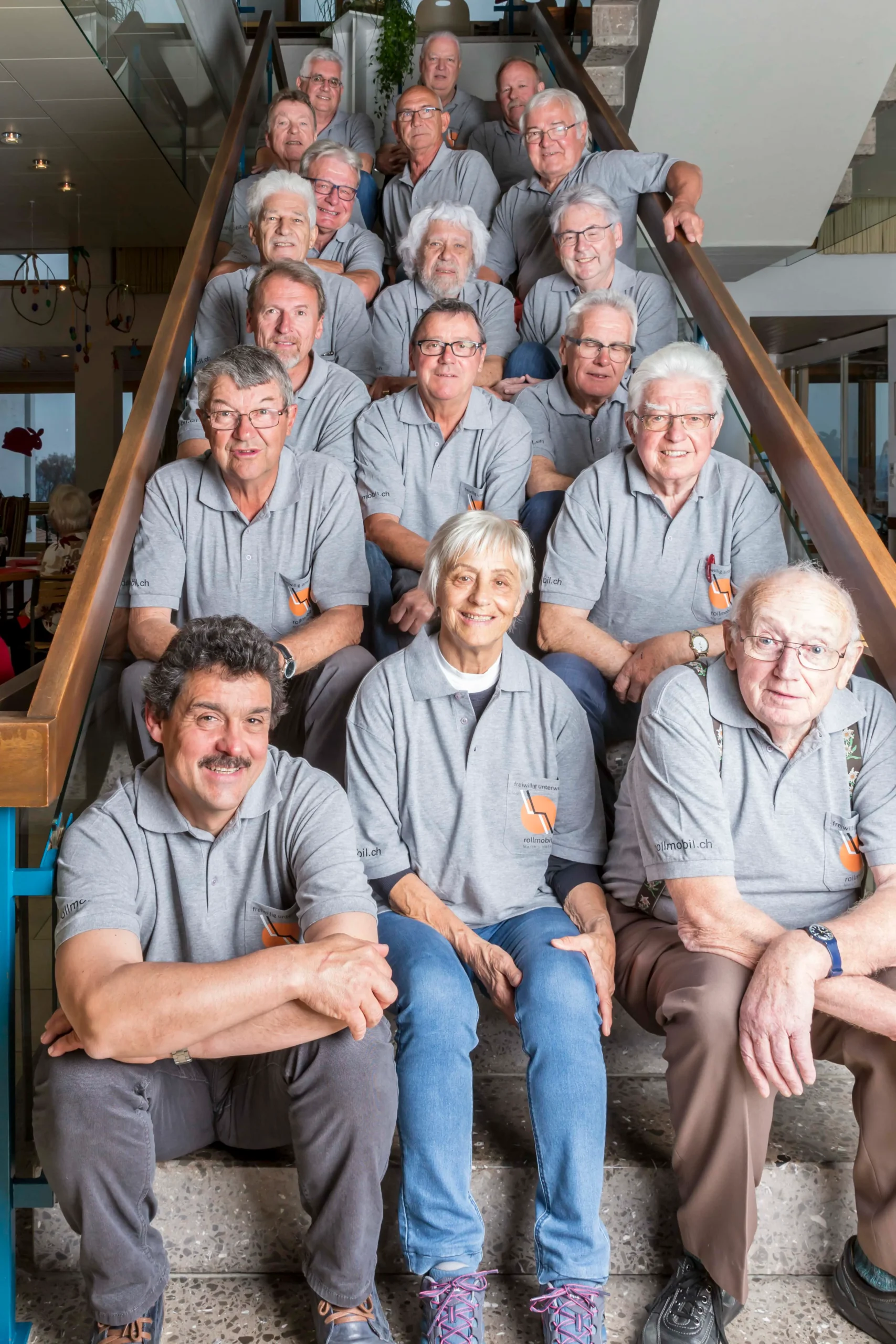 Mitglieder/-innen des Vereins Rollmobil March-Höfe, die auf einer Treppe sitzen