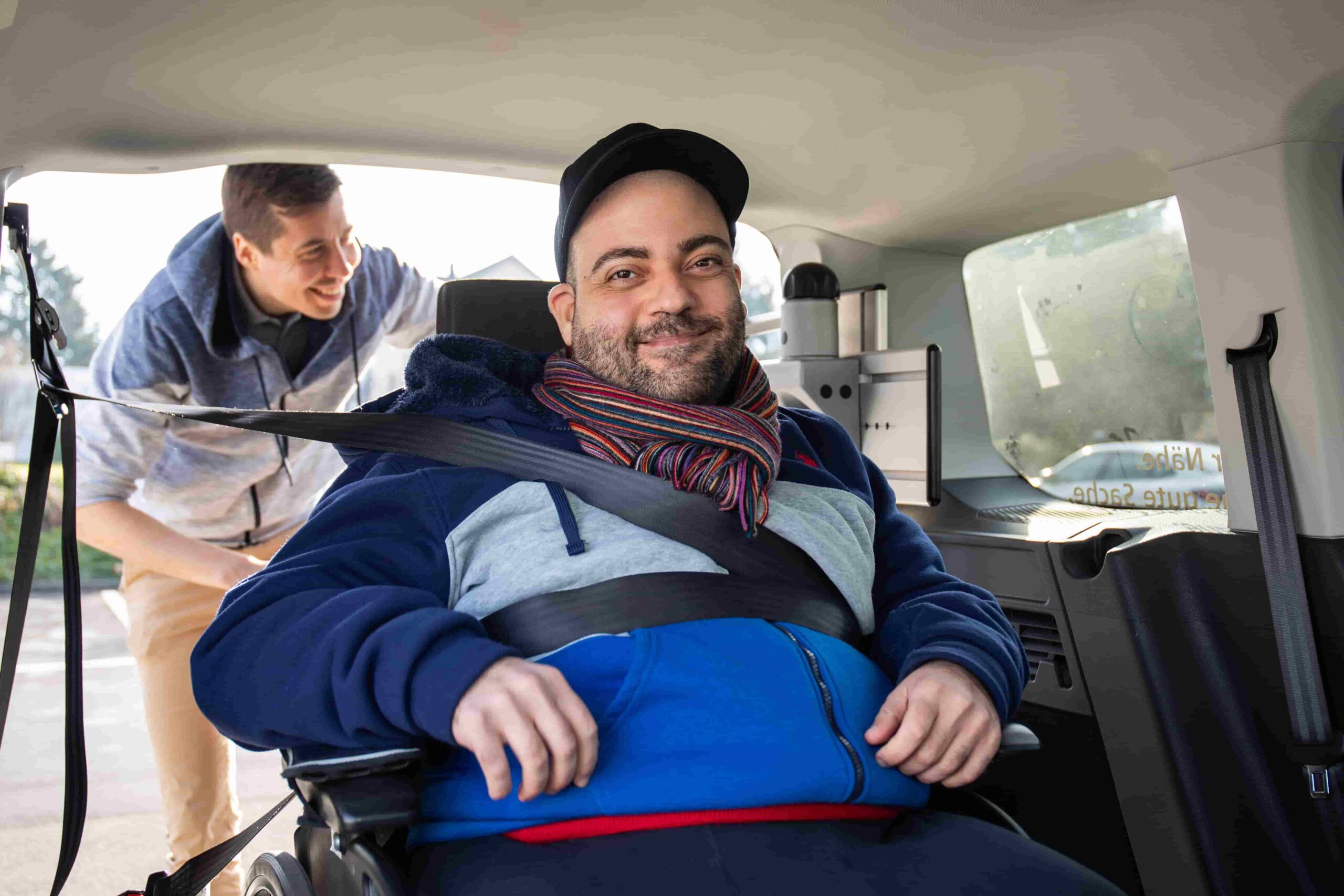 Ein Rollstuhlfahrer lächelt im Fahrzeug von rollmobil March-Höfe