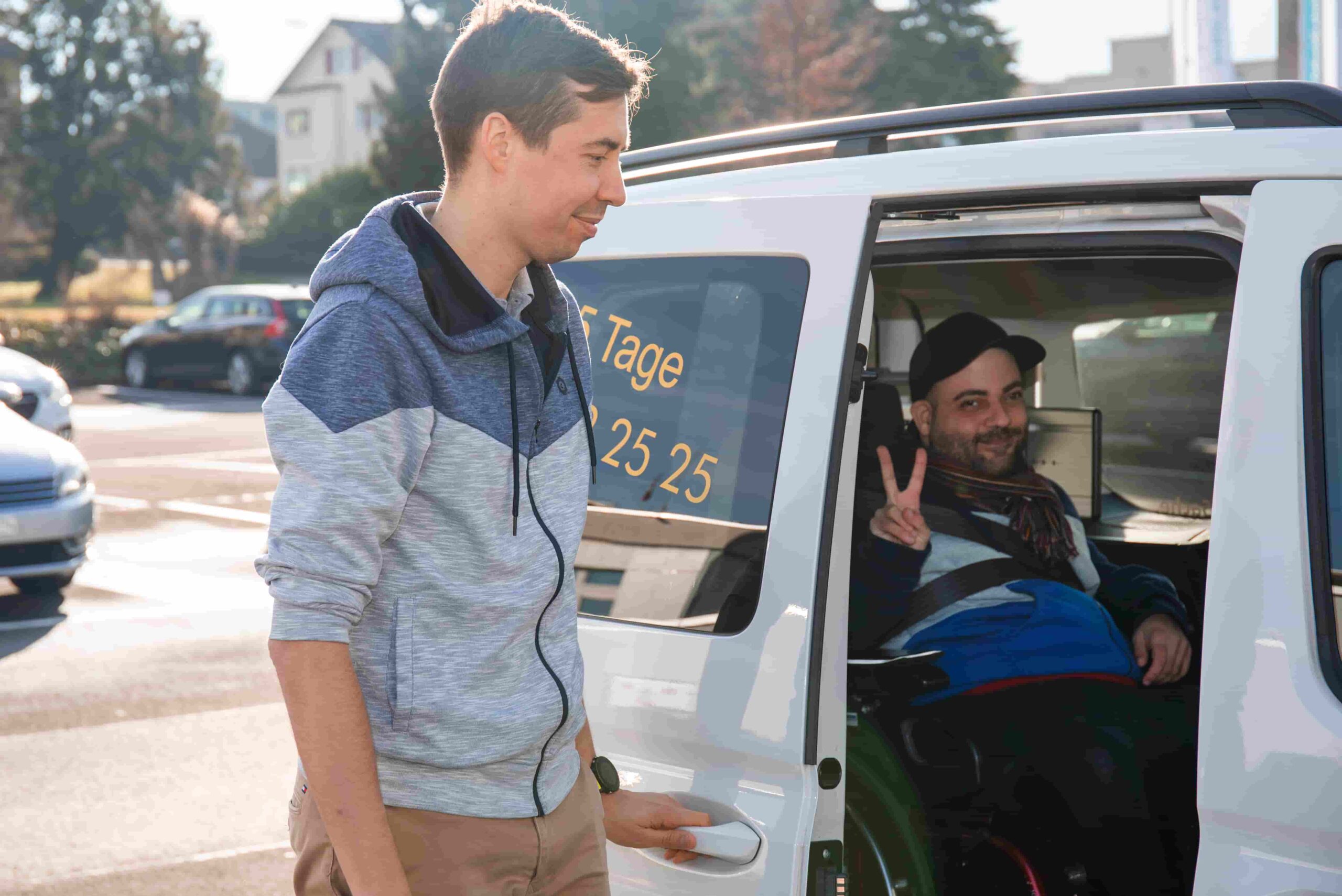 Spezial-Fahrzeug mit Rampe für Rollstuhl-Fahrer/-innen. Fahrer/-in, welche die Rampe zum Aufladen des Fahrgastes bereitstellt