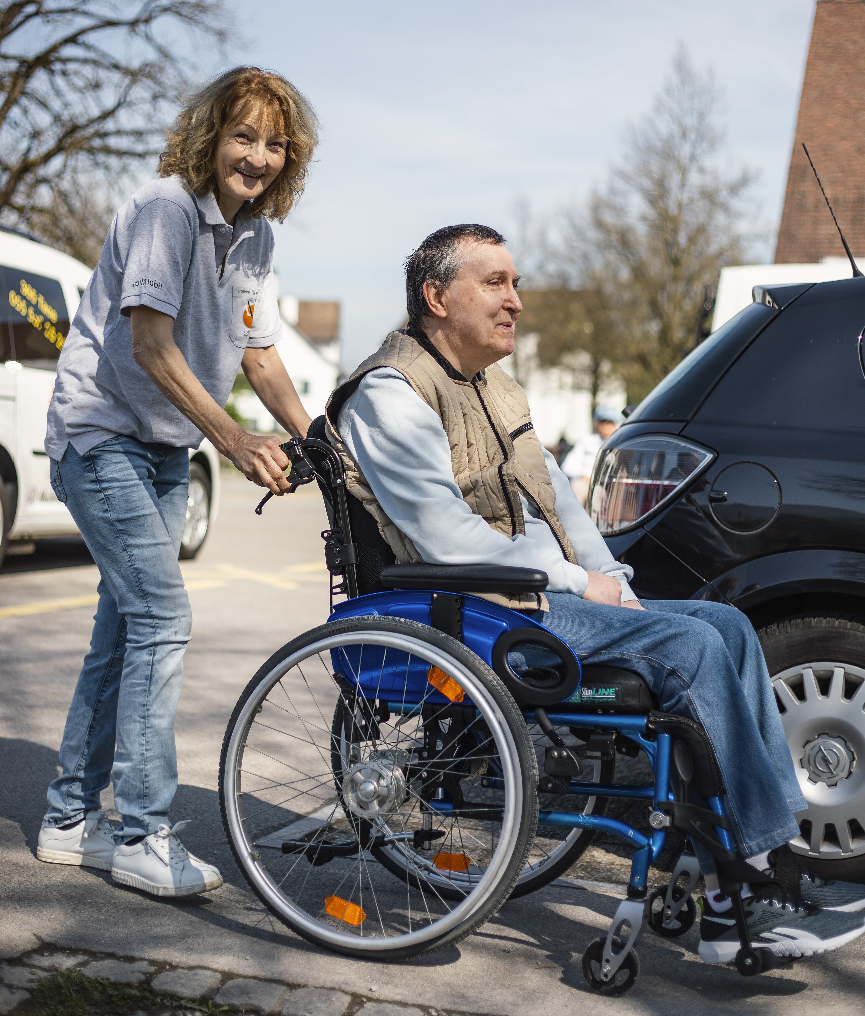 Spezial-Fahrzeug mit Rampe für Rollstuhl-Fahrer/-innen. Fahrer/-in, welche die Rampe zum Aufladen des Fahrgastes bereitstellt